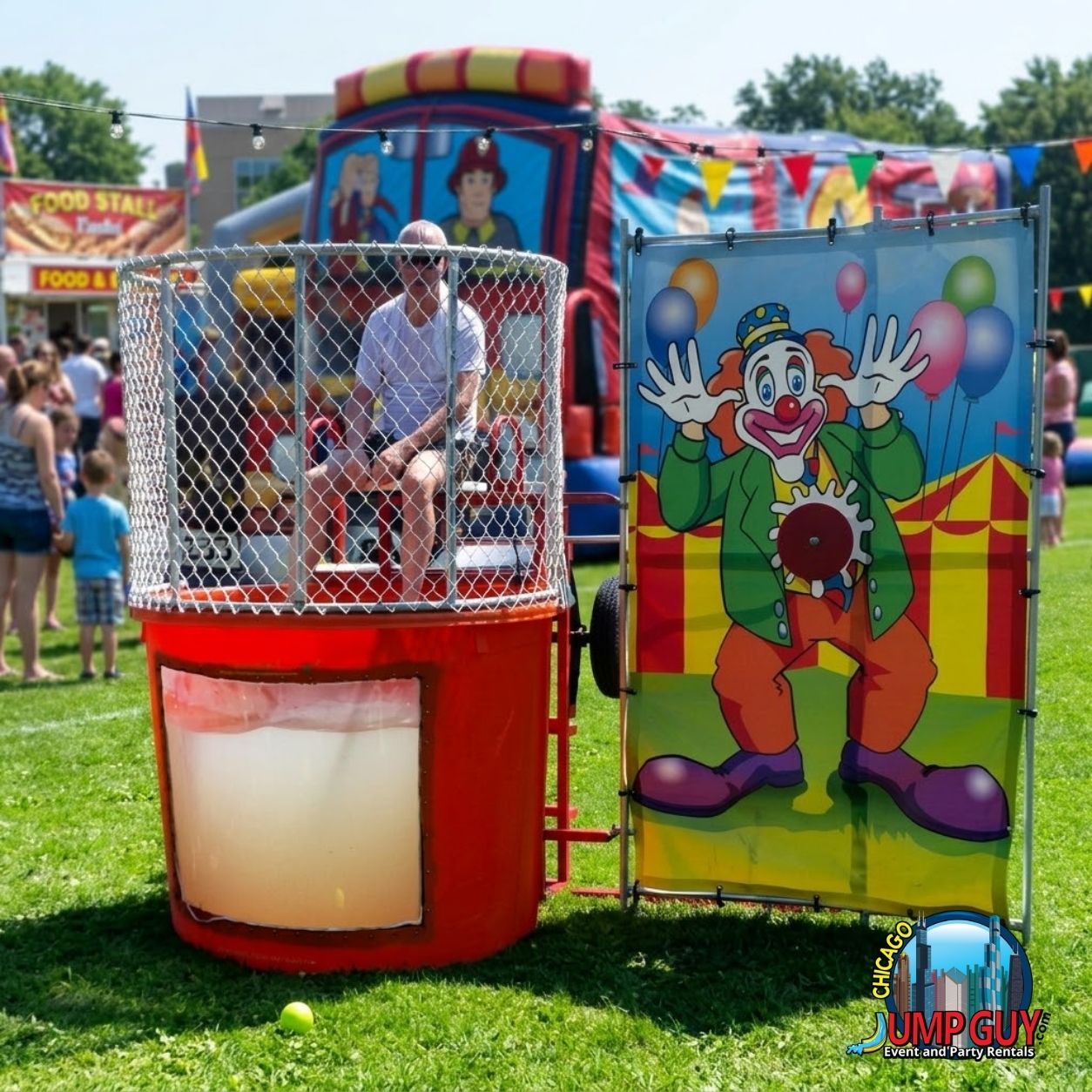 Volunteer seated in a dunk tank cage at a block party